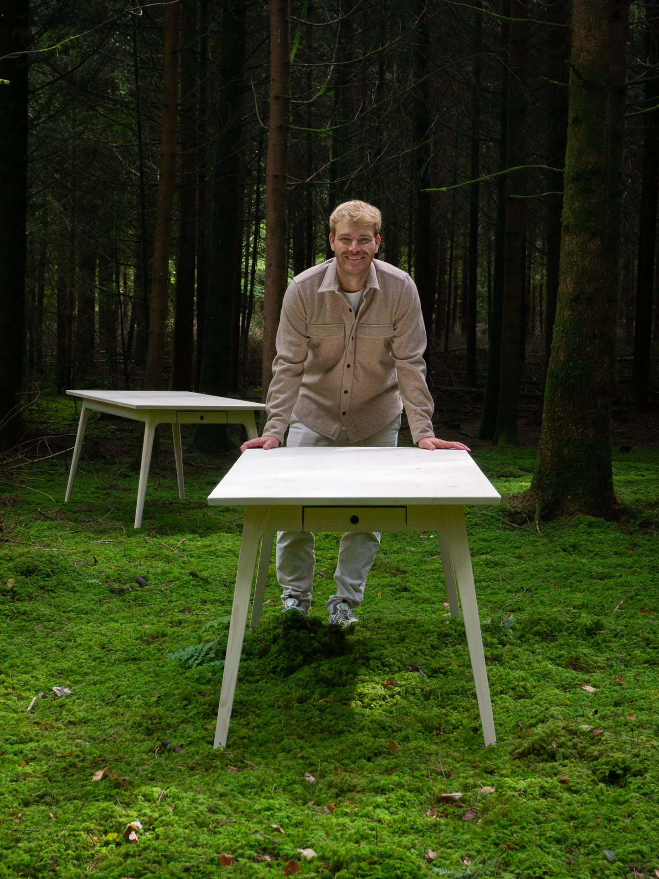 Tobias Zimmermann, Gründer von Zimmerwaud, im Wald mit zwei Tischen