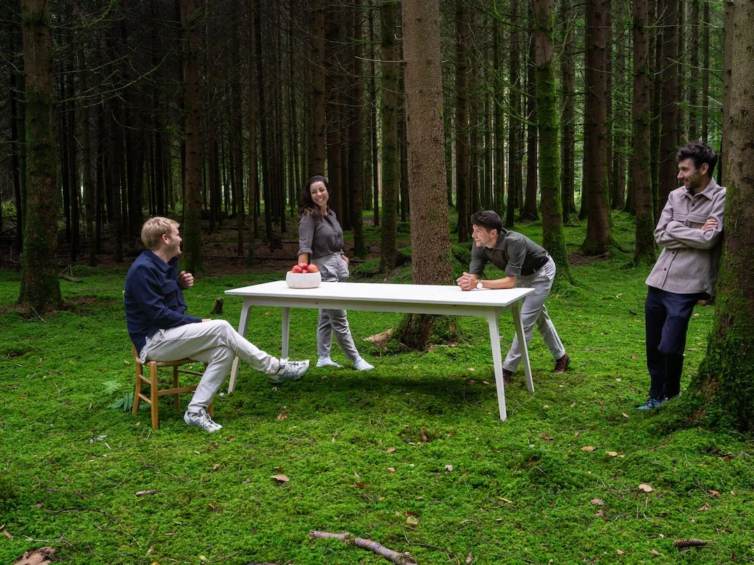Das Team von Zimmerwaud rund um einen Tisch im Schweizer Wald